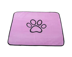 Close-up detail of the soft pink pet pee pad featuring a cute black paw print pattern.