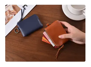 Close-up detail of mini leather coin purse with card holder slots and metal ring.