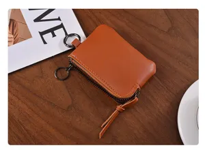 Detail view of mini leather coin purse with zipper closure, compact key pouch and metal hook.