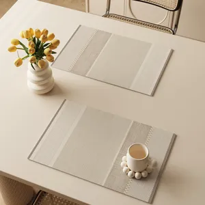 Detail view of beige waterproof placemat with elegant striped texture for dining table setup.