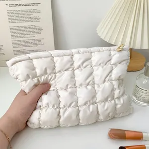 White quilted cotton makeup bag with zipper closure, soft padded cosmetic pouch for travel.