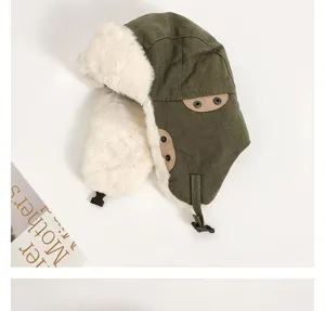 Winter warm trapper hat detail shot, green fabric with thick white plush earflaps and strap.