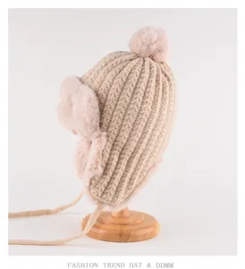 Cozy knitted winter hat detail featuring plush earflaps, pompom, and warm fleece lining.