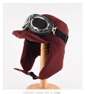 Vista dettagliata del cappello da aviatore invernale rosso scuro con occhiali e paraorecchie.