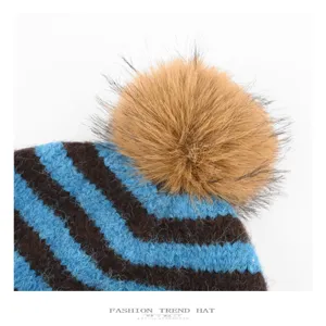 Cozy winter striped knit hat featuring a fluffy faux fur pom pom for warmth and style.