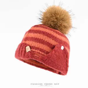 Winter warm striped knitted hat with plush pom pom and earflaps for women main product view.