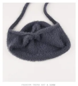 Dark grey fuzzy knit detail view of cozy winter earflap hat with long soft straps.