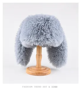 Vista detallada del gorro ushanka de invierno gris esponjoso con orejas largas en soporte.