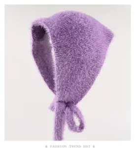 Primo piano del dettaglio del berretto in maglia viola soffice, sciarpa peluche con laccetti.