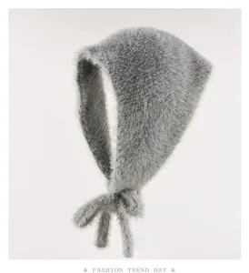 Dettaglio cappello lavorato a maglia grigio soffice con morbida pelliccia e lacci carini.