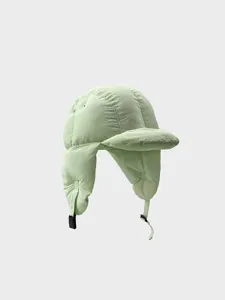 Detailed view of the light green quilted winter trapper hat with cozy ear flaps and strap.