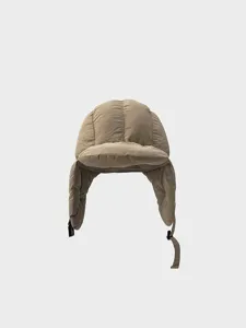 Winter quilted trapper hat close-up, warm ear flaps and adjustable buckle design detail.