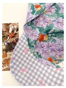Detail view of French retro Monet garden floral print and blue plaid patchwork sun protection hat.