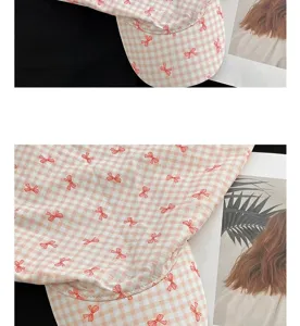 Close-up detail of pink gingham bow baseball cap, soft cotton breathable fabric fashion hat.