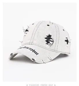 Stiloso cappellino da baseball in denim slavato vintage con frange e dettagli ricamati.