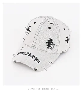 Dettaglio berretto da baseball in denim rovinate, tessuto vintage lavato e ricamo.