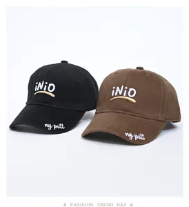 Detail view of casual Korean baseball caps in black and brown with custom embroidery designs.