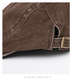 Washed denim flat cap detail showing vintage texture, contrast stitching and metal buckle.