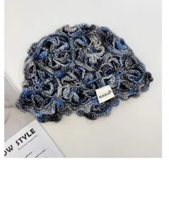 Close-up of handmade crochet hollow bucket hat showing intricate blue gradient yarn.