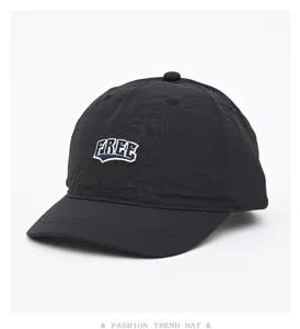 Nahaufnahme der schwarzen, schnelltrocknenden Baseballkappe mit gesticktem FREE-Schriftzug.