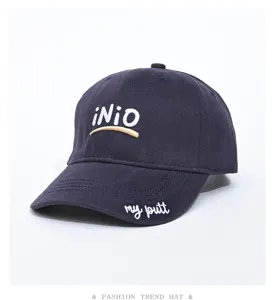 Navy blue cotton baseball cap with embroidered lettering and wide curved brim for casual wear.
