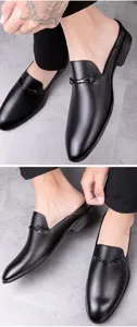 Detail view of men's leather backless loafers showing fine metal buckle and cowhide texture.