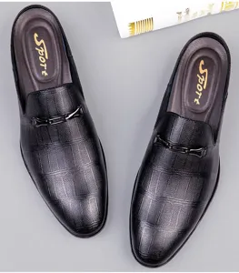 Detail of men's black leather slip-on mule shoe with metal buckle and crocodile texture.