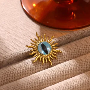 Exquisite sun shape brooch featuring blue cat eye stone and gold plated finish detail.