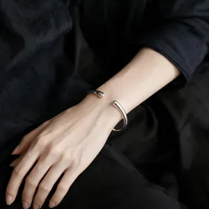 Bracciale rigido aperto in argento con design a goccia liscia, gioiello unisex minimalista.
