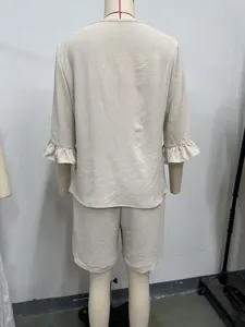 Achteraanzicht detail van een chique beige dames tweedelig set met volantmouwen en shorts.