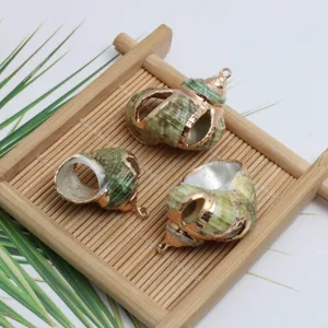 Nahaufnahme von natürlichen Muschel-Schnecken-Anhängern mit vergoldeten Kanten für DIY Schmuck.