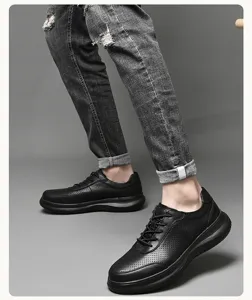 Vista detallada de zapatos casuales de cuero negro con diseño perforado y suela.