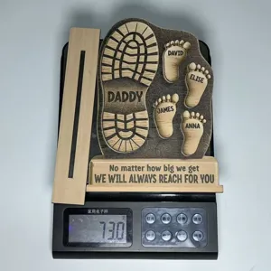 Wooden father's day footprint plaque detail, personalized family names engraved design.