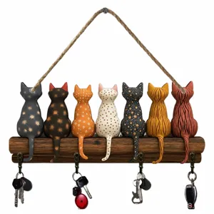 Detail van houten muur sleutelhouder met handgeschilderde schattige kattenbeeldjes.