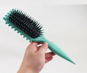 Detail view of the green hair brush with bristle and air cushion for daily hair styling care.