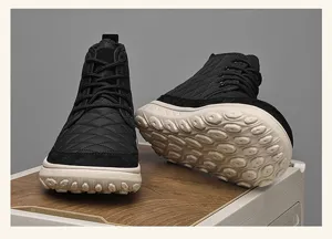 Close-up of black winter snow boot detail, quilted texture and thick white outsole.