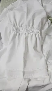 Weiße Damenbluse Detail mit eleganten gesmokten elastischen Bündchen und feinen Nähten.