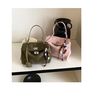 Stylish suede women handbag with metal turn-lock and bead pendant, chic daily shoulder bag.