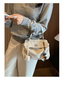 Minimalist suede women handbag detail view, large capacity shoulder briefcase with chic bead charm.
