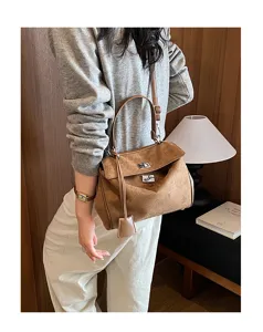 Detail view of the brown suede shoulder bag worn by model, showcasing texture and hardware.