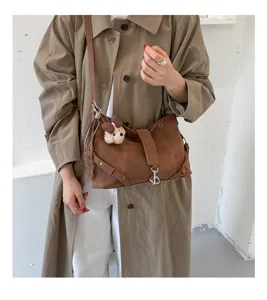 Braune Retro Achsel-Umhängetasche am Model getragen, zeigt elegante Riemen und stilvolle Details.