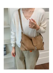 Detailansicht der braunen Vintage-Umhängetasche am Model mit Schnallen- und Riemendesign.