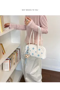 Elegante bolso de hombro blanco con lunares azules y lindo colgante de oso para uso diario.