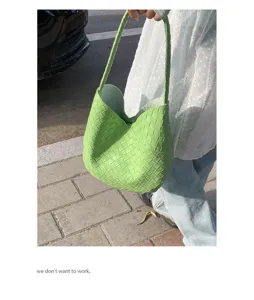 Green woven leather shoulder bag detailed shot, showing the classic intrecciato texture.