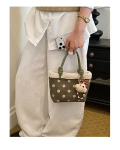 Detailansicht der Retro Pünktchen Wildleder Handtasche mit Plüsch und Bärenanhänger.