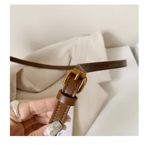 Nahaufnahme des braunen Ledergürtelrihmens mit Metallschließe und feiner Textur und Hardware.