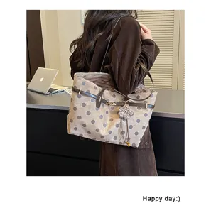 Brown suede polka dot tote bag detail, vintage shoulder bag with flower charm and leather strap.
