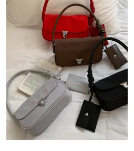 Minimalist nylon underarm shoulder bag for women with matching card holder and twist strap.