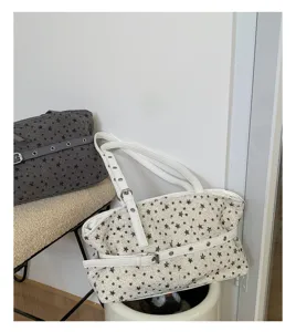 Λεπτομερής εικόνα της vintage τσάντας tote από tweed με σχέδιο αστεριών, μοτίβο και υφή.