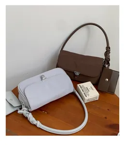 Minimalist nylon underarm shoulder bag for women with chic metal lock and matching card pouch.